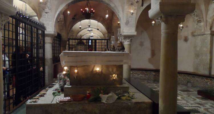 Intérieur d'une église de pierre faiblement éclairée.