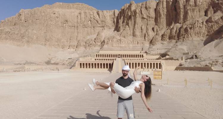 Man die vrouw vasthoudt voor oude kliffen en bouwwerken.