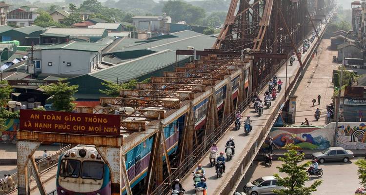 Un grand pont avec de la circulation et un train qui le traverse.