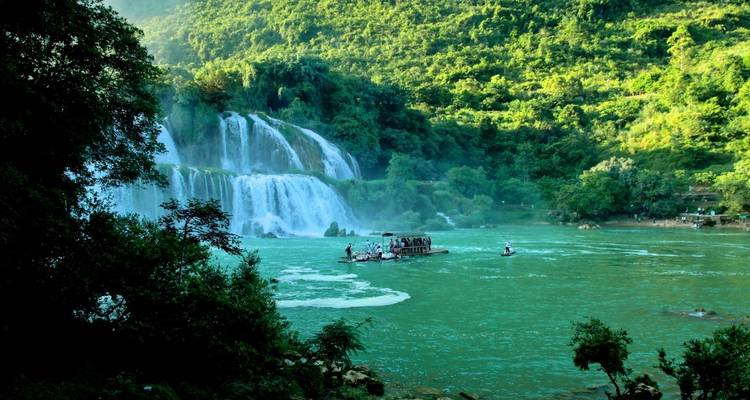 Un groupe de personnes sur un radeau près d'une grande cascade.