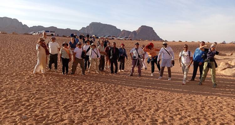 Groupe de touristes dans un paysage désertique avec des formations rocheuses.