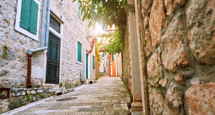 Narrow cobblestone street with colorful buildings.