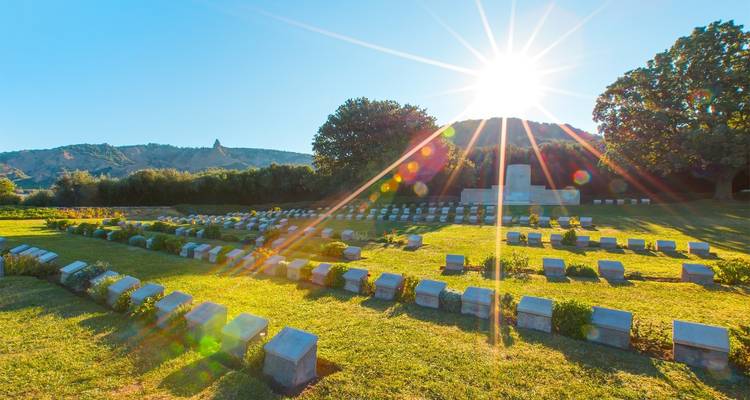 Cementerio de guerra con destello solar de fondo.
