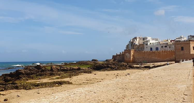 Escena costera con edificios históricos y el mar.