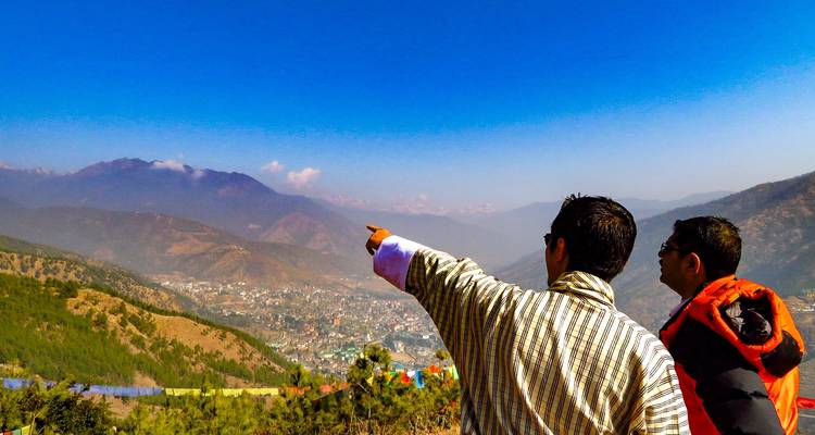 Dos personas con vistas a un valle con montañas.