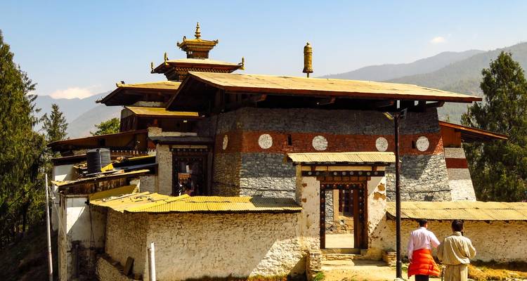 Edificio tradicional butanés con personas en atuendo tradicional.