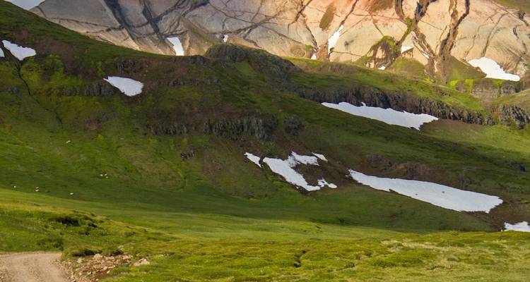 View of mountainous terrain with patches of snow.