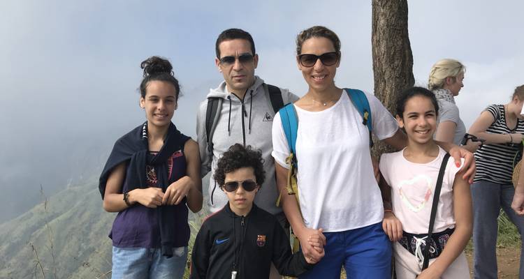 Family posing for a photo with a mountainous backdrop.
