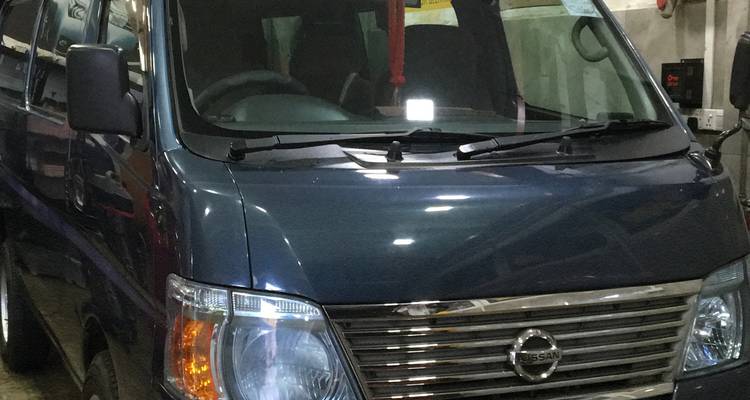 Nahaufnahme eines dunkel gefärbten Transporters, der drinnen geparkt ist und teilweise sichtbar ist.