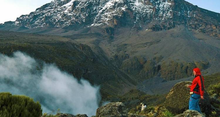 Hiker looking at a mist-covered mountain landscape.