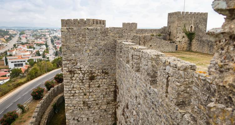 Les murs de pierre médiévaux et les tours du château d'Obidos surplombent la ville blanchie à la chaux en contrebas.