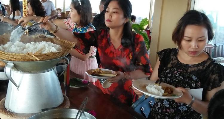 Des gens qui se servent du riz à un buffet dans un restaurant.