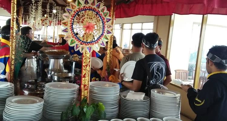 Des gens dans une file de buffet dans un cadre décoré.