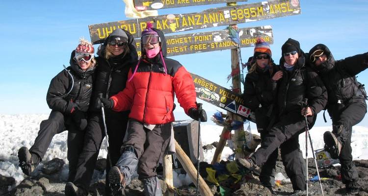 Grupo de escaladores posando en la cumbre del Kilimanjaro.