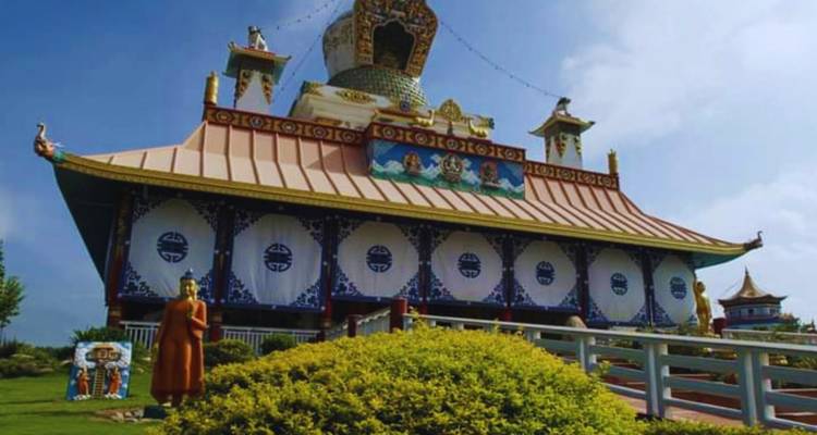 A Buddhist temple with ornate architecture and a statue in front.