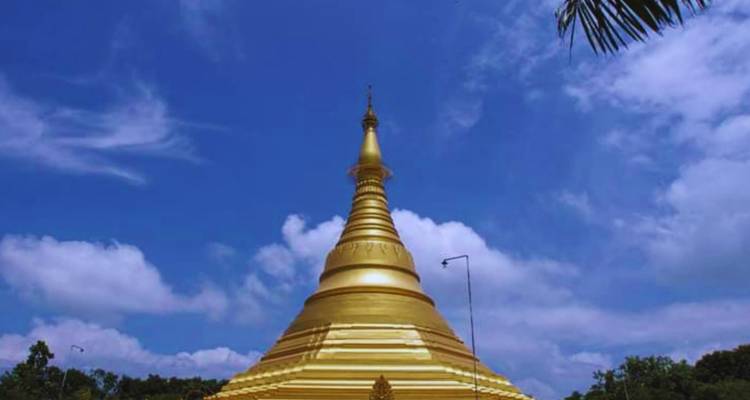 A golden stupa under a clear blue sky.