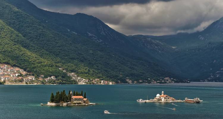 Two small islets with church buildings in the middle of a bay.
