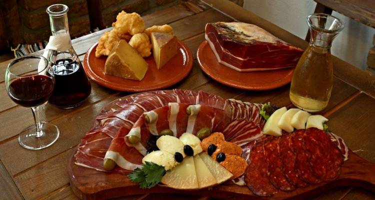 Traditional Montenegrin meal with various meats, cheese, and wine.