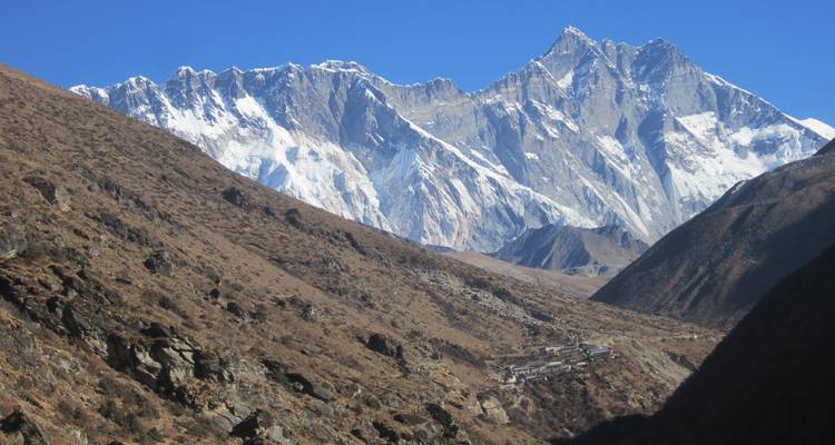 Chaîne de montagnes enneigée dans une vallée aride.