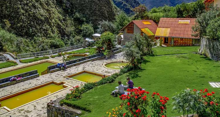 Colourful hot-spring resort in a lush Andean valley with stone pools, gardens and mountains around
