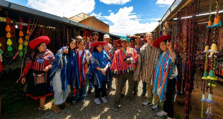 Los visitantes con coloridos ponchos tradicionales posan dentro del mercado de artesanías.