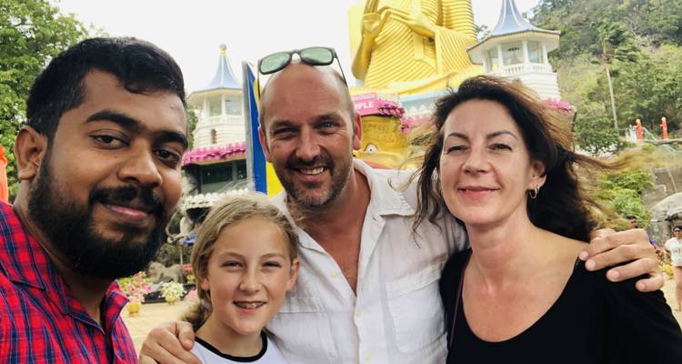 Famille prenant un selfie devant une grande statue dorée de Bouddha.