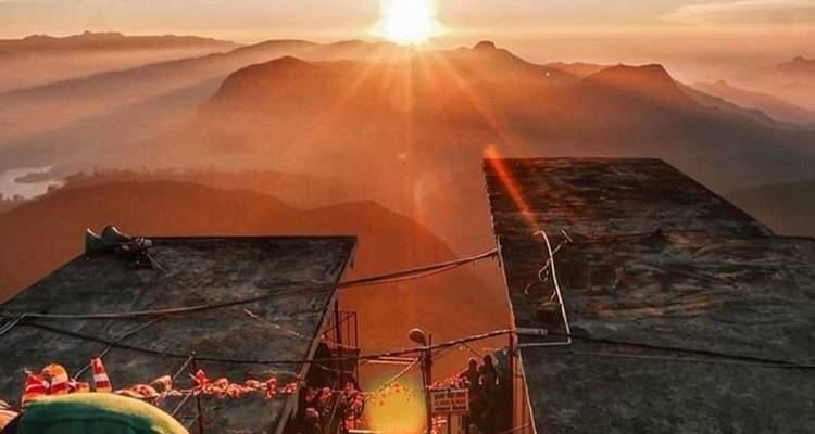 Lever de soleil sur un paysage montagneux avec un point d'observation.