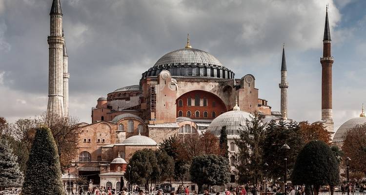 Historic building with minarets and a cloudy sky background.