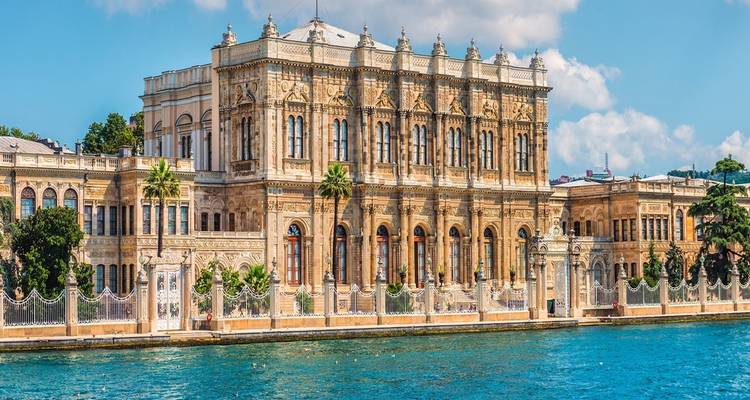 Palace-like building by a waterfront with ornate architecture.