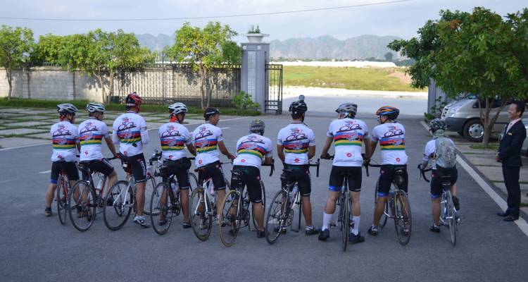 Eine Gruppe von Radfahrern, die mit dem Rücken zugewandt an einer Straßenkreuzung stehen.