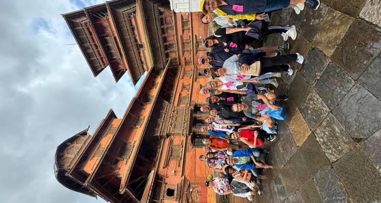Un groupe de touristes posant devant un bâtiment historique.