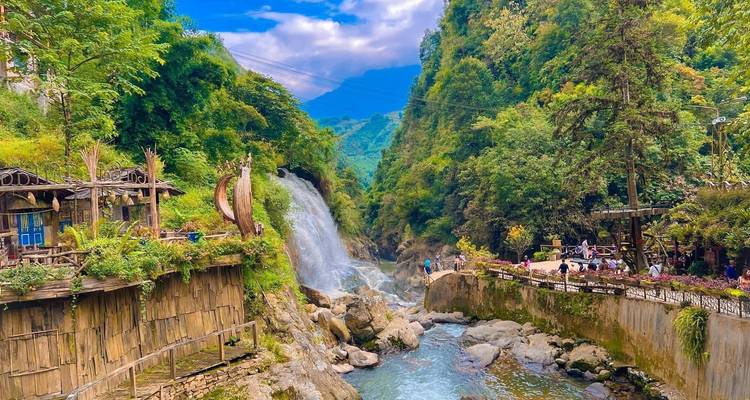 Waterval en rivier die door een bebost gebied stroomt