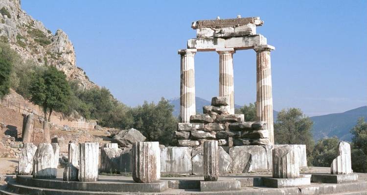 Alte Tempelruinen in einer bergigen Landschaft.