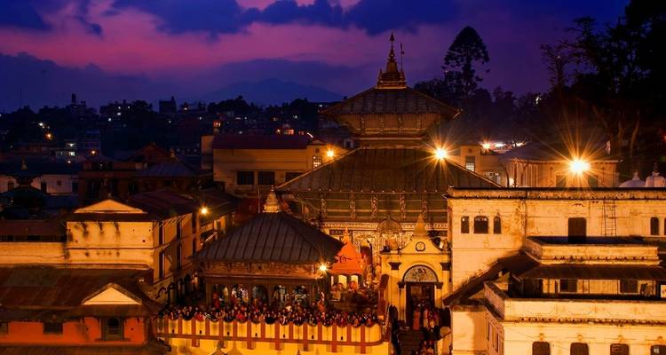 Tempelcomplex bij zonsondergang met verlichte structuren.