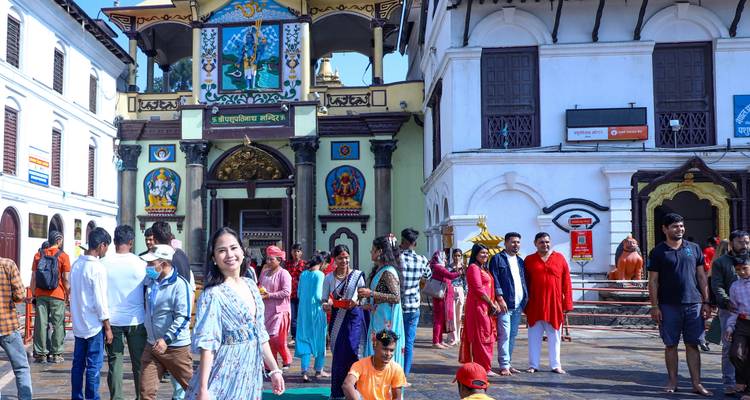 Des gens en vêtements traditionnels à l'entrée d'un temple.