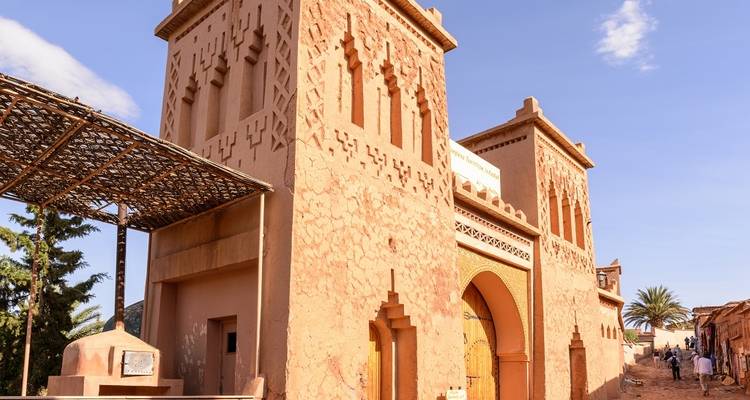 Adobe-Torturm im Stil von Ouarzazate mit dekorativen Mustern unter klarem Himmel.