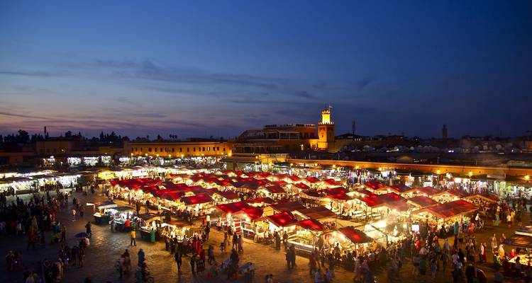 Vibrant evening market scene with illuminated stalls.