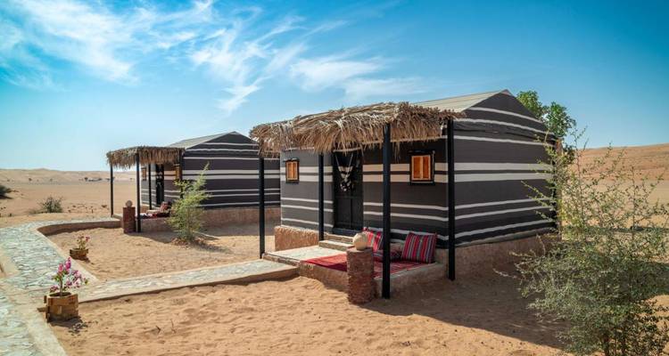 Tiendas de campaña tradicionales del desierto bajo un cielo azul.