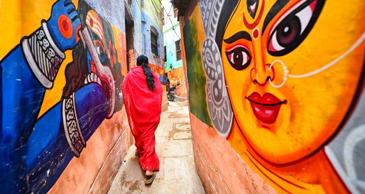 Vibrant alleyway with murals and a person walking.