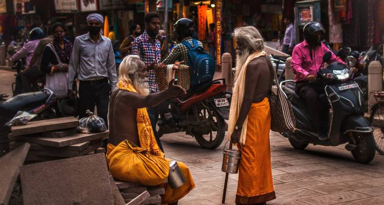 Two elderly men in conversation on a busy street.