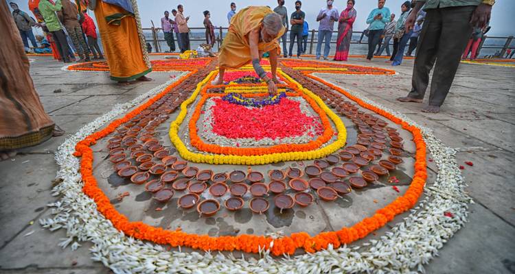 Intricate flower decoration on the ground with people participating.