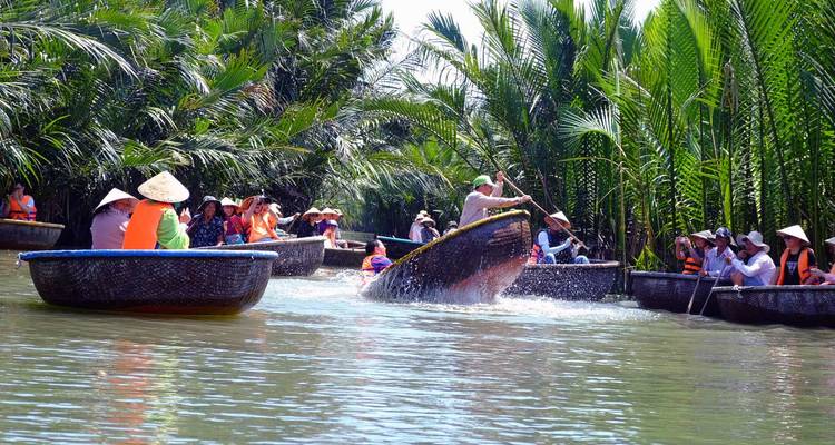 Des gens ramant en bateau sur une rivière tropicale.