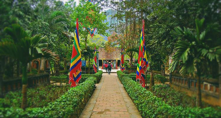Weg gesäumt mit Flaggen, der zu einem Tempel führt.