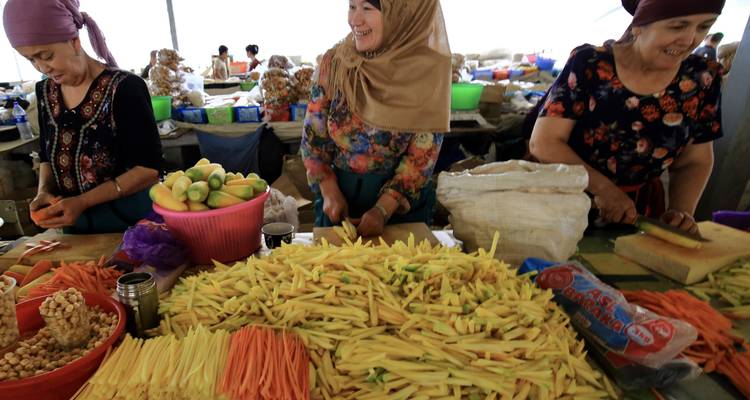 Vrouwen die lokale producten voorbereiden aan een marktkraam.