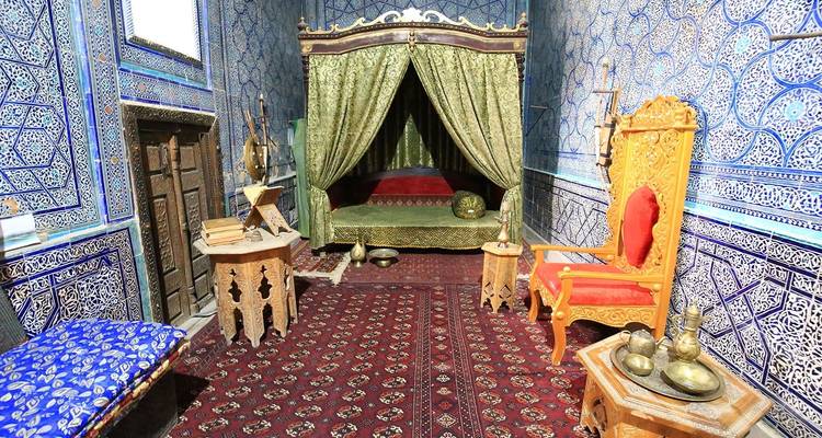 Interieur van een kamer met sierlijke decoratie en rijke textielstoffen.