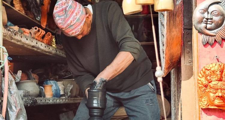 Handwerker arbeitet an Töpferwaren in einer bunten Werkstatt.