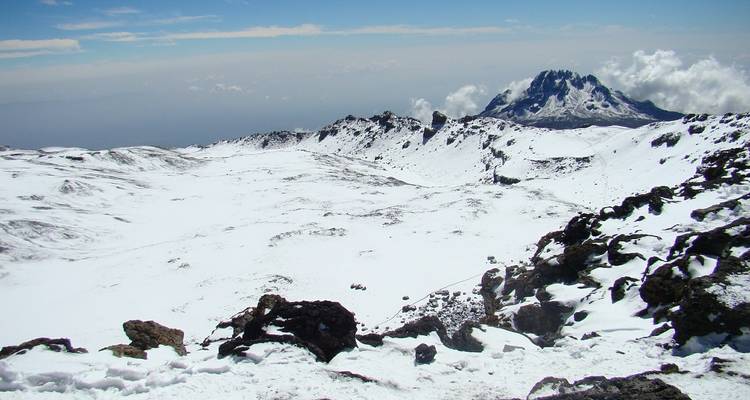 Schneebedeckte Berglandschaft mit entferntem Gipfel.