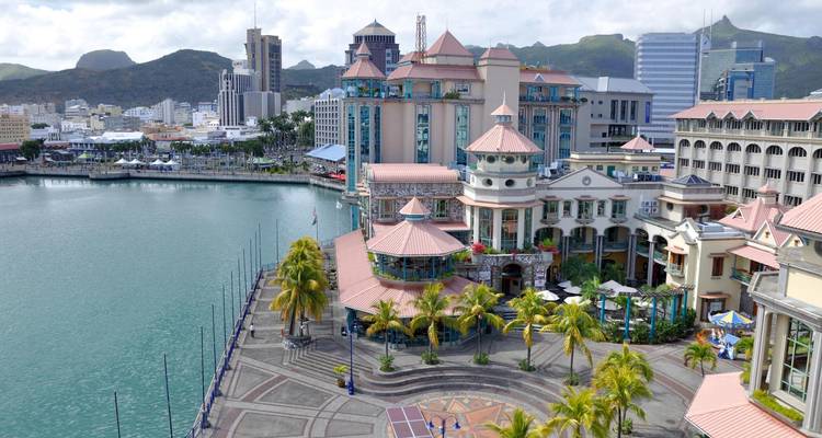 Luchtfoto van de waterkant van Port Louis met modern hotelcomplex, jachthaven en bergachtergrond
