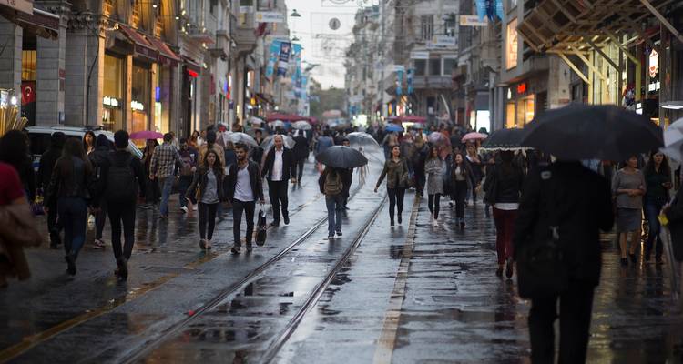 People walking on a wet street holding umbrellas.