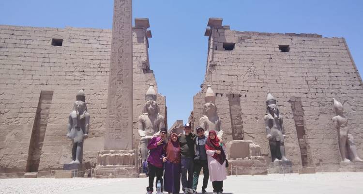 Grupo posando frente a un templo egipcio antiguo con estatuas.